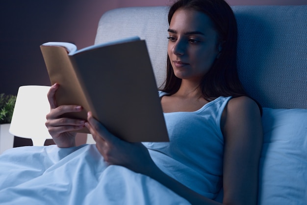 Mujer, libro de lectura, en cama