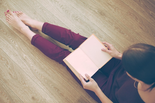 Mujer, libro de lectura, en el piso