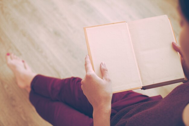 Mujer, libro de lectura, en el piso