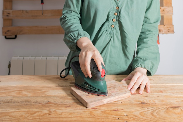 Foto mujer lijando una madera restaurada