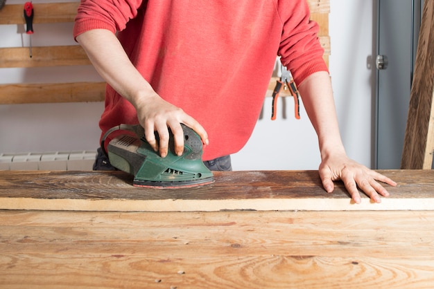 Mujer lijando una madera restaurada