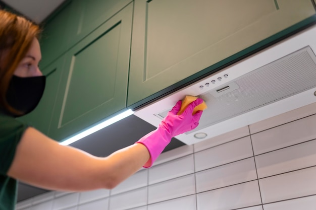 Mujer limpiando el capó en la cocina