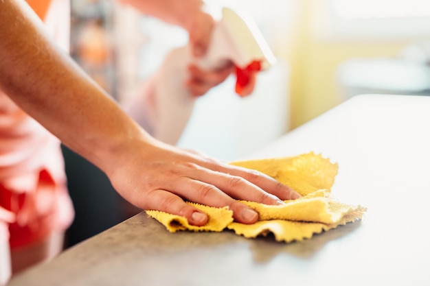 Mujer limpiando la mesa con un paño de microfibra Detalle de primer plano Concepto de limpieza