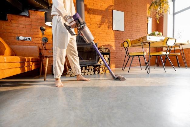 Foto mujer limpiando piso con aspiradora de mano