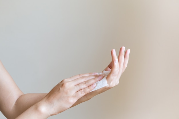 Mujer limpiando sus manos con papel de seda blanco suave