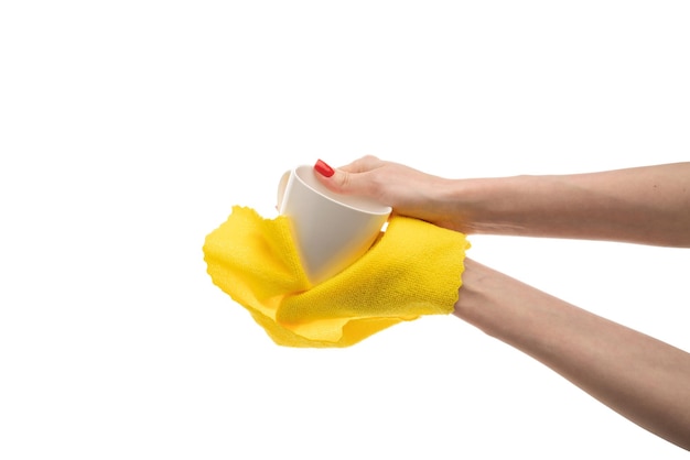 Mujer limpiando una taza blanca con una toalla en el primer plano de la cocina