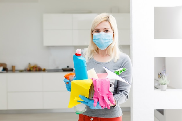 Mujer limpieza de cocina. Prevención de coronavirus y desinfección domiciliaria.