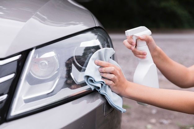 Mujer, limpieza, faros del coche