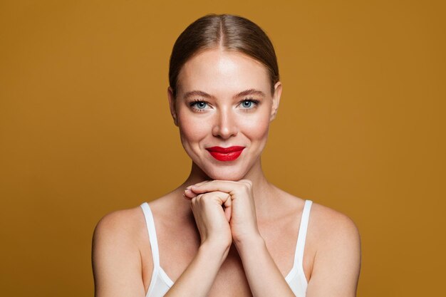 Mujer linda y alegre en un retrato de fondo amarillo