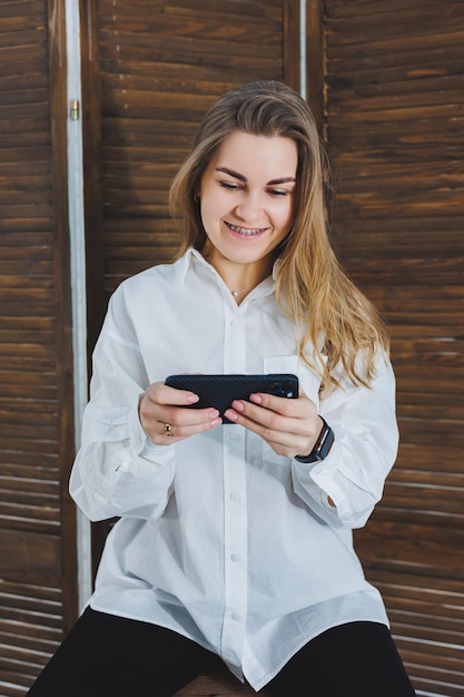 Una mujer linda con una camisa blanca con emociones brillantes de risa en su rostro Mujer feliz