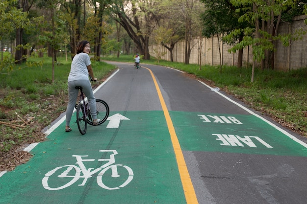 La mujer linda está montando su bicicleta.