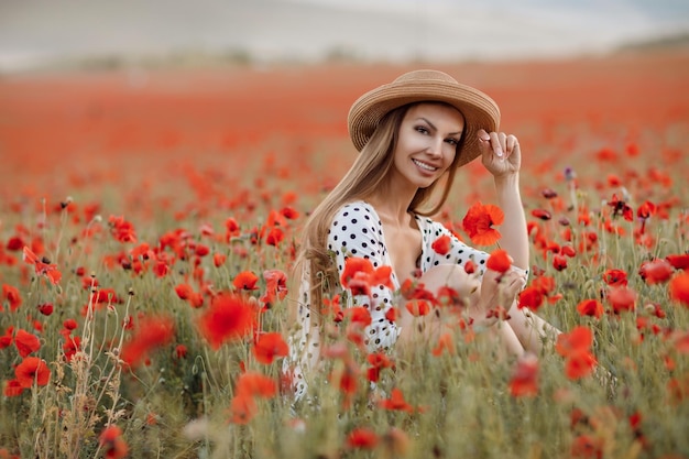 Mujer linda joven en un campo de amapolas