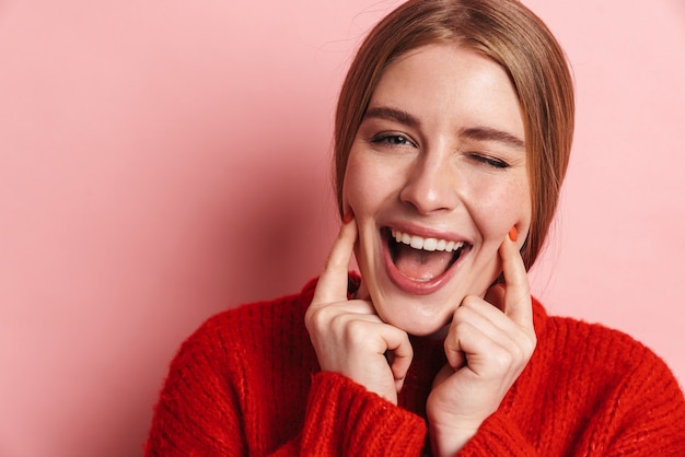 Foto mujer linda joven positiva posando aislada sobre pared rosa.