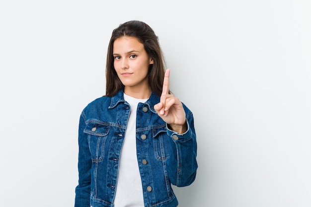 Foto mujer linda joven que muestra el número uno con el dedo.