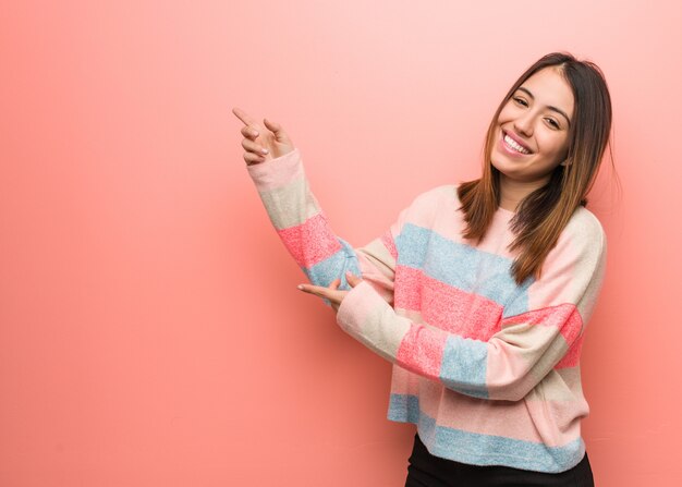 Mujer linda joven que señala al lado con el dedo