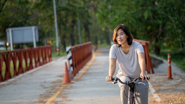 Foto la mujer linda está montando su bicicleta.