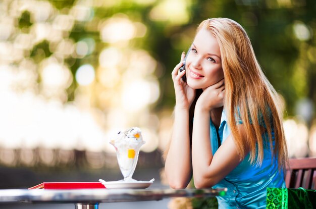 Mujer linda que sostiene el teléfono cerca de cara