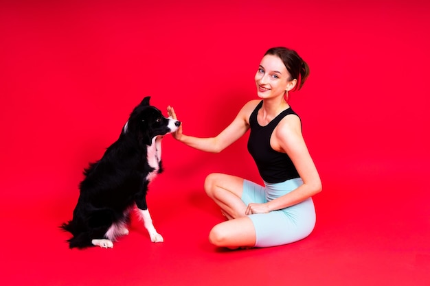 Mujer con un lindo perro border collie está en el estudio de deporte con mascota