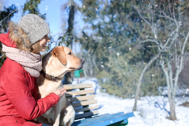 Mujer con lindo perro en el parque el día de invierno Amistad entre mascota y dueño