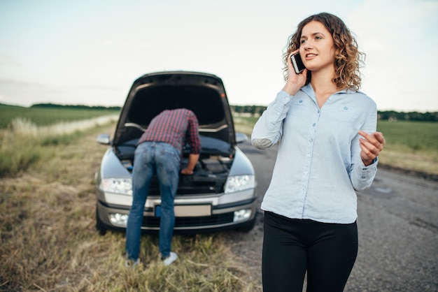 Mujer llama al servicio técnico, hombre repara coche roto