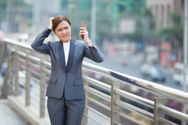 Mujer llamando al teléfono inteligente y se siente enojada