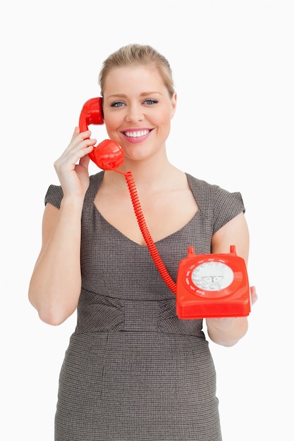 Mujer llamando con un teléfono de línea