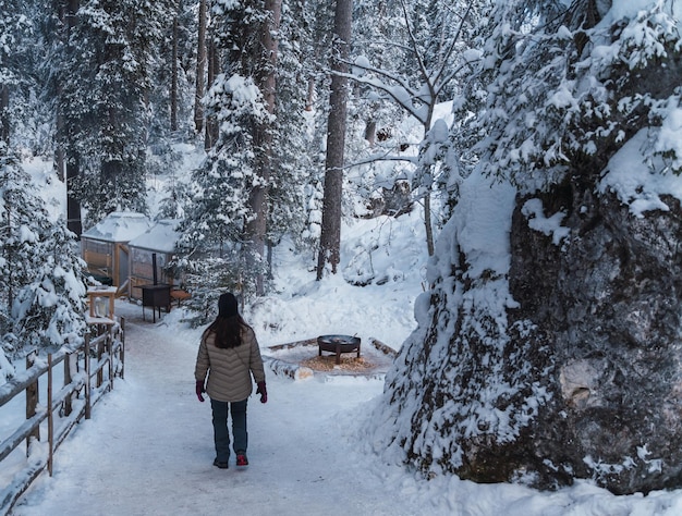 Mujer llega a una fogata en medio del bosque nevado