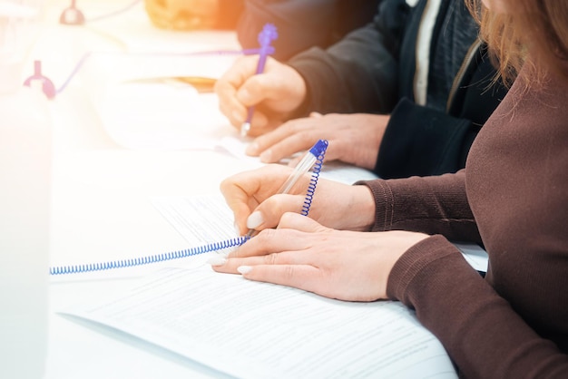 La mujer llena el formulario de solicitud en blanco en la mesa o firma el contrato