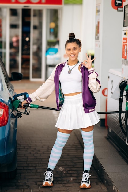 Mujer llenando su auto con combustible en una gasolinera