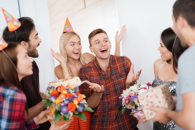 La mujer lleva a la fiesta sorpresa del hombre. Cumpleaños Boy sonrisas.