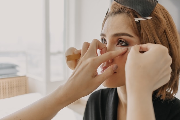 La mujer lleva maquillaje de la maquilladora.