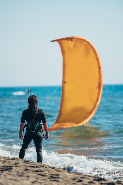 Foto mujer, llevando, cometa, arnés, y, un, wetsuit, en, un, playa