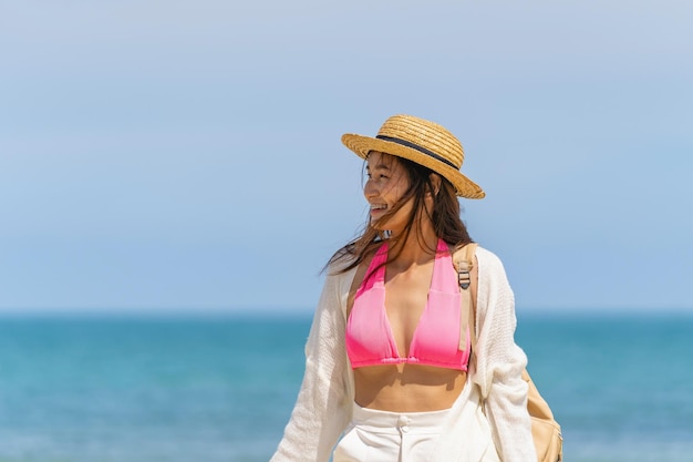 mujer, llevando, sombrero de paja, con, bolsa, posición, en, playa