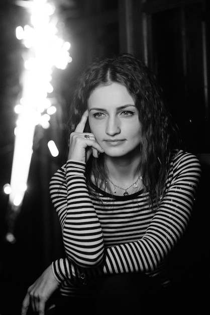 Mujer con luces bokeh dentro de una casa de madera a altas horas de la noche