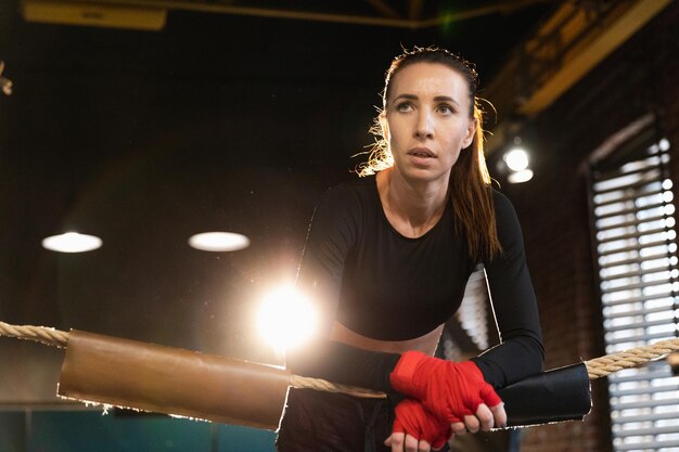 Mujer luchadora chica poder mujer luchadora con boxeo rojo envuelve vendajes protectores de pie en el boxeo