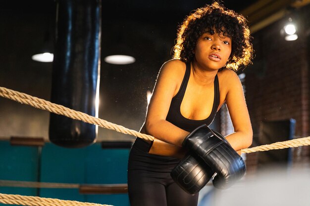 Mujer luchadora girl power mujer afroamericana luchadora con guantes de boxeo de pie en el ring de boxeo l