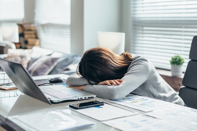 La mujer en el lugar de trabajo está descansando, cansada del trabajo.