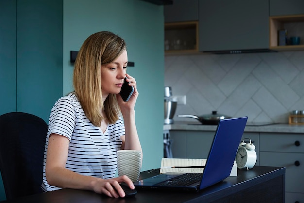 Mujer en el lugar de trabajo de la oficina en casa usando una computadora portátil independiente que trabaja en la sala de estar mirando la lap