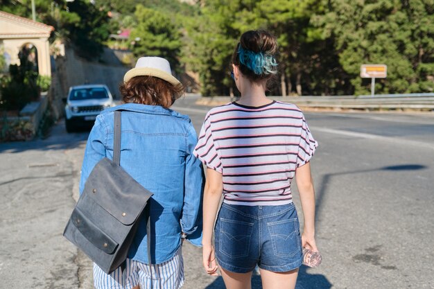 Mujer madre e hija adolescente caminando en un día soleado de verano