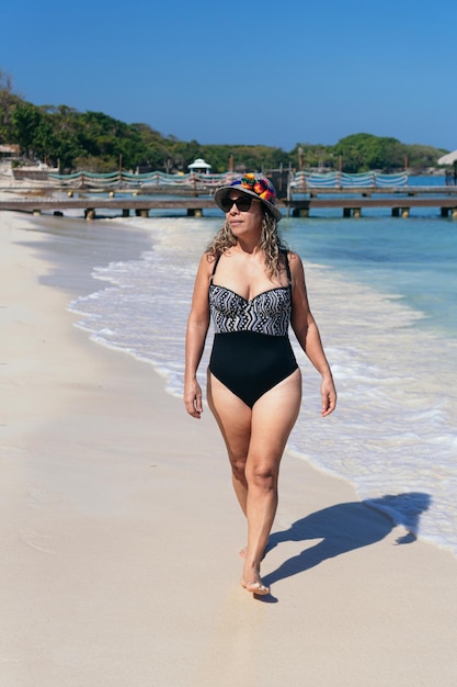 mujer madura, ambulante, en la playa, en, traje de baño