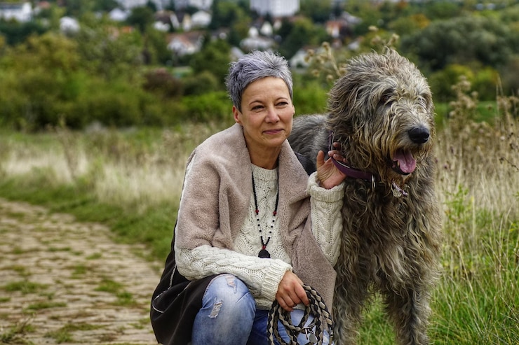 Foto mujer madura arrodillada junto al perro