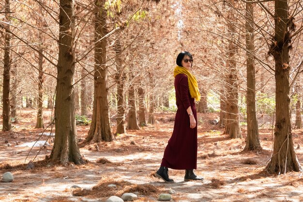 Mujer madura asiática moderna caminar en el bosque