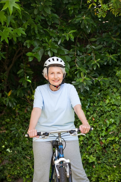 Mujer madura, biking de montaña, afuera