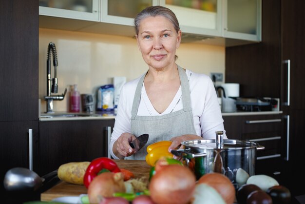 Mujer madura en la cocina preparando la comida