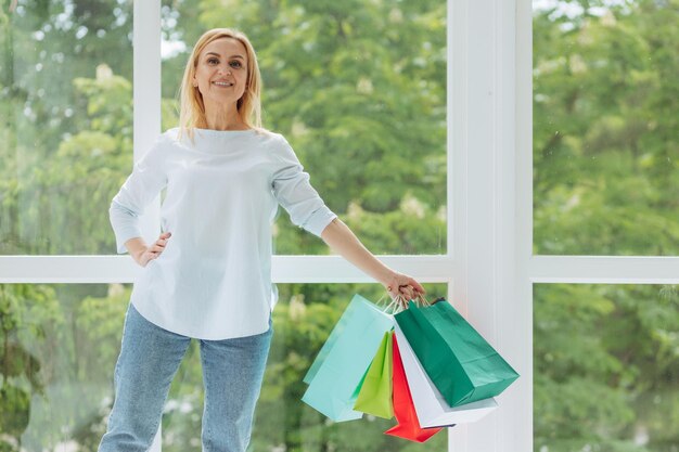 mujer madura, con, colorido, bolsas de compras, en casa