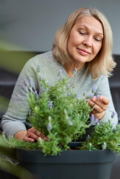 Mujer madura cuidando flores caseras