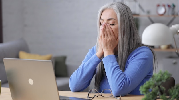 Mujer madura deprimida recibió malas noticias en línea. Síndrome de Burnout, exceso de trabajo, depresión.