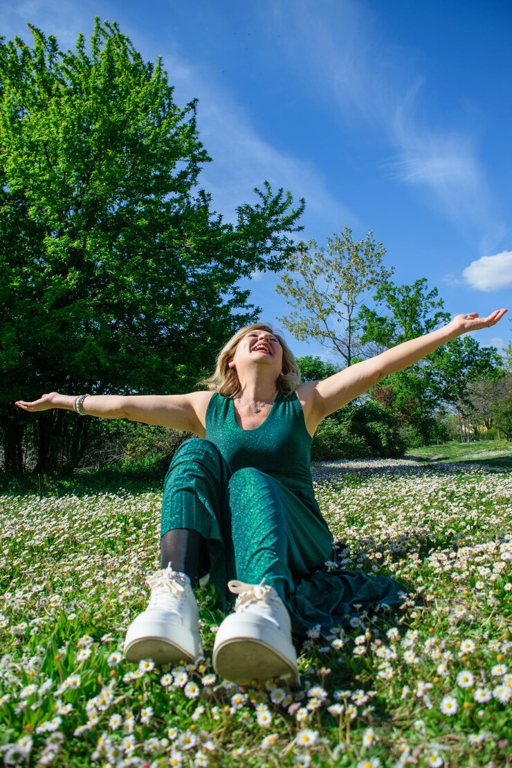 Mujer madura feliz en la hierba con marguerites Menopausia y concepto del día de la madre