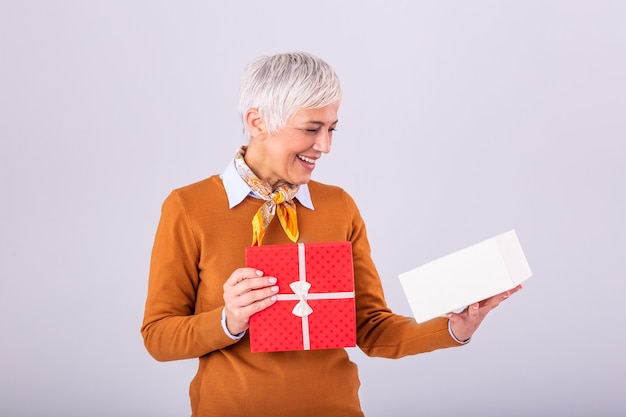 Mujer madura feliz que sostiene la caja de regalo