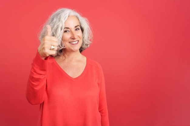 Foto mujer madura gesticulando acuerdo levantando el pulgar